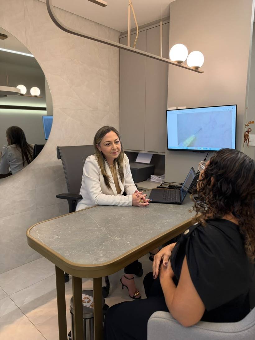 Dra. Aline conversando com uma paciente durante a consulta